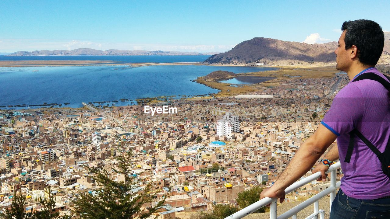 Man looking at cityscape while standing by railing