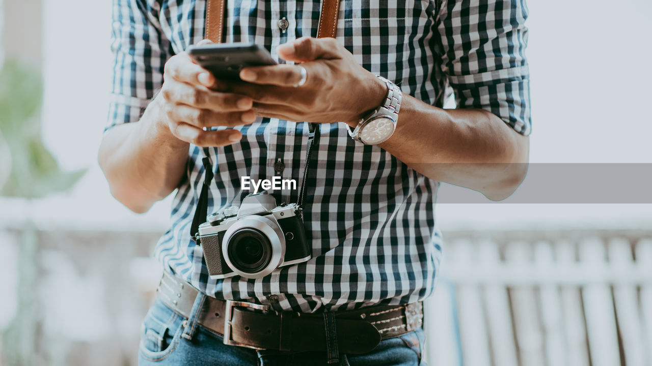 Midsection of man using mobile phone