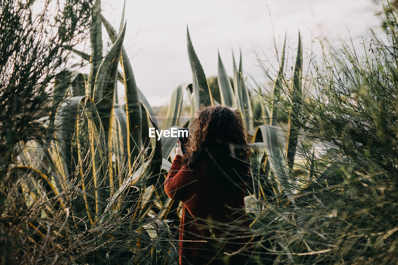 Woman photographing in field