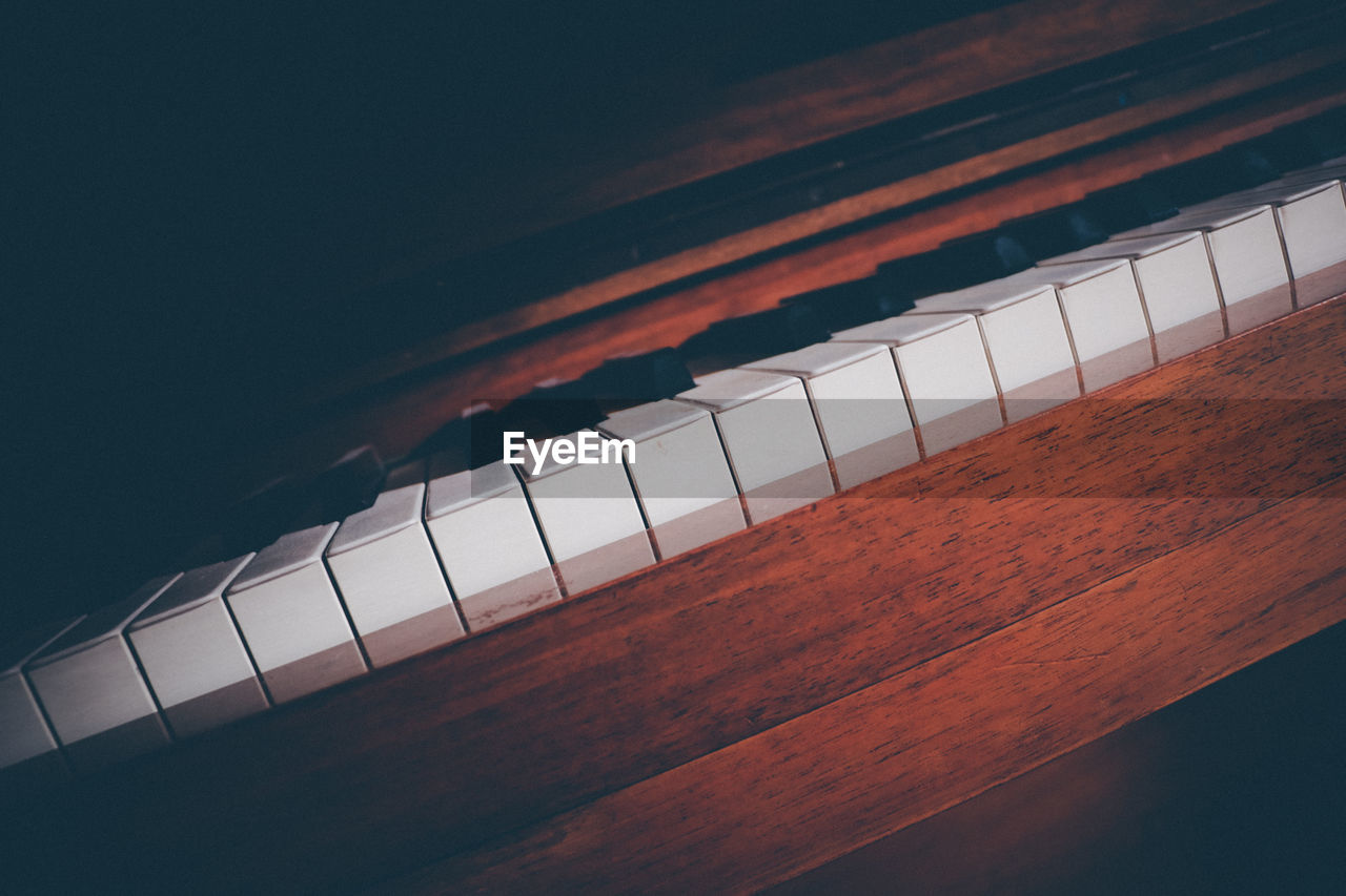 High angle view of piano keys on table against black background