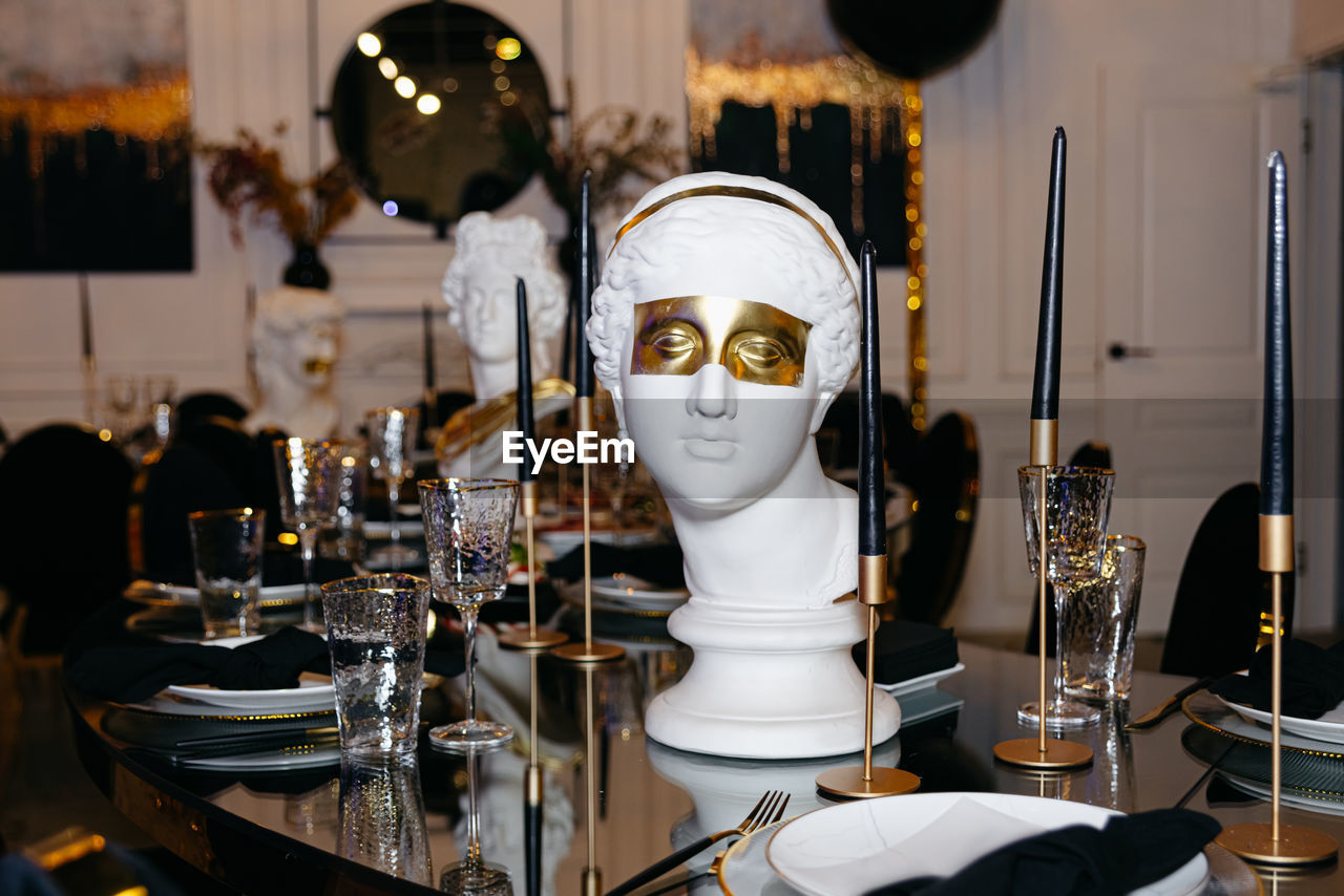 Exquisite table arrangement featuring champagne glasses and a white marble bust of a greek goddess