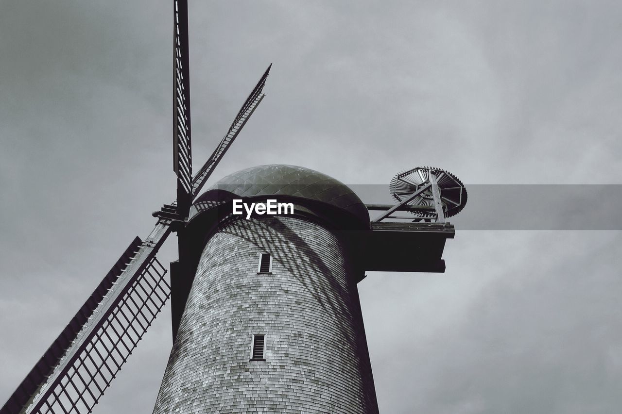 Low angle view of windmill against cloudy sky