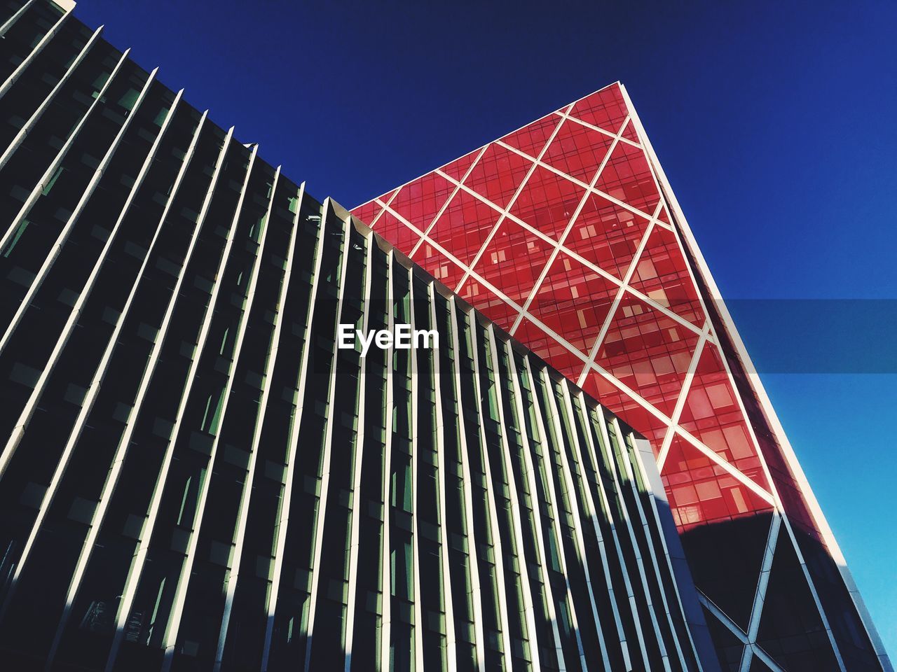 Low angle view of modern buildings against clear blue sky