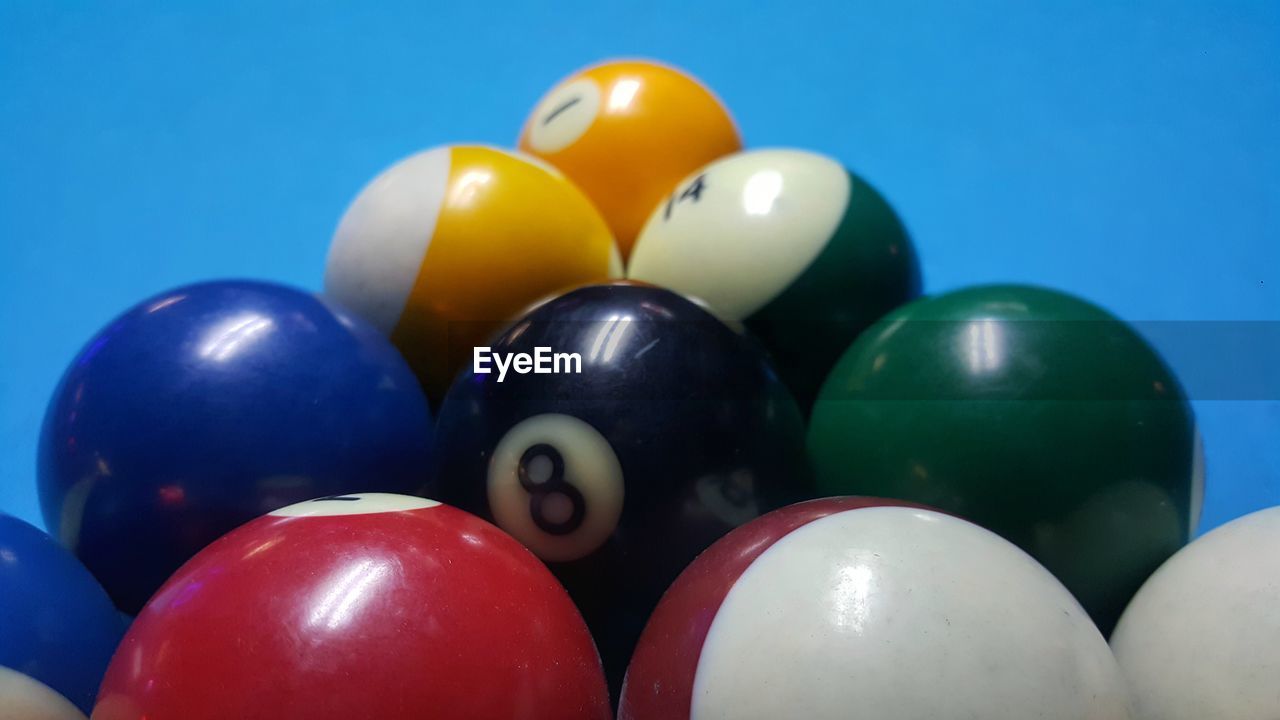 CLOSE-UP OF COLORFUL BALLS ON TABLE AGAINST BLUE BACKGROUND