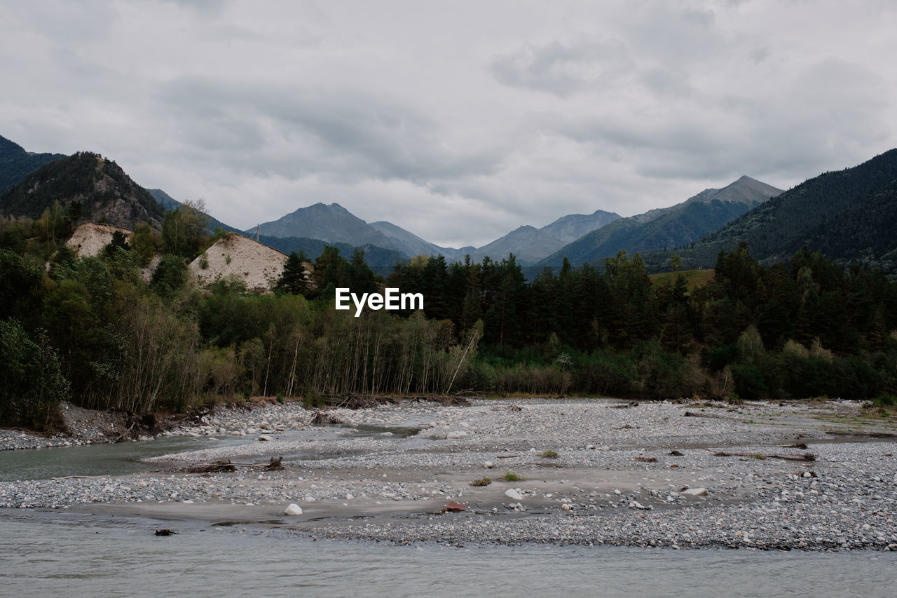 Scenic view of river and mountains against sky