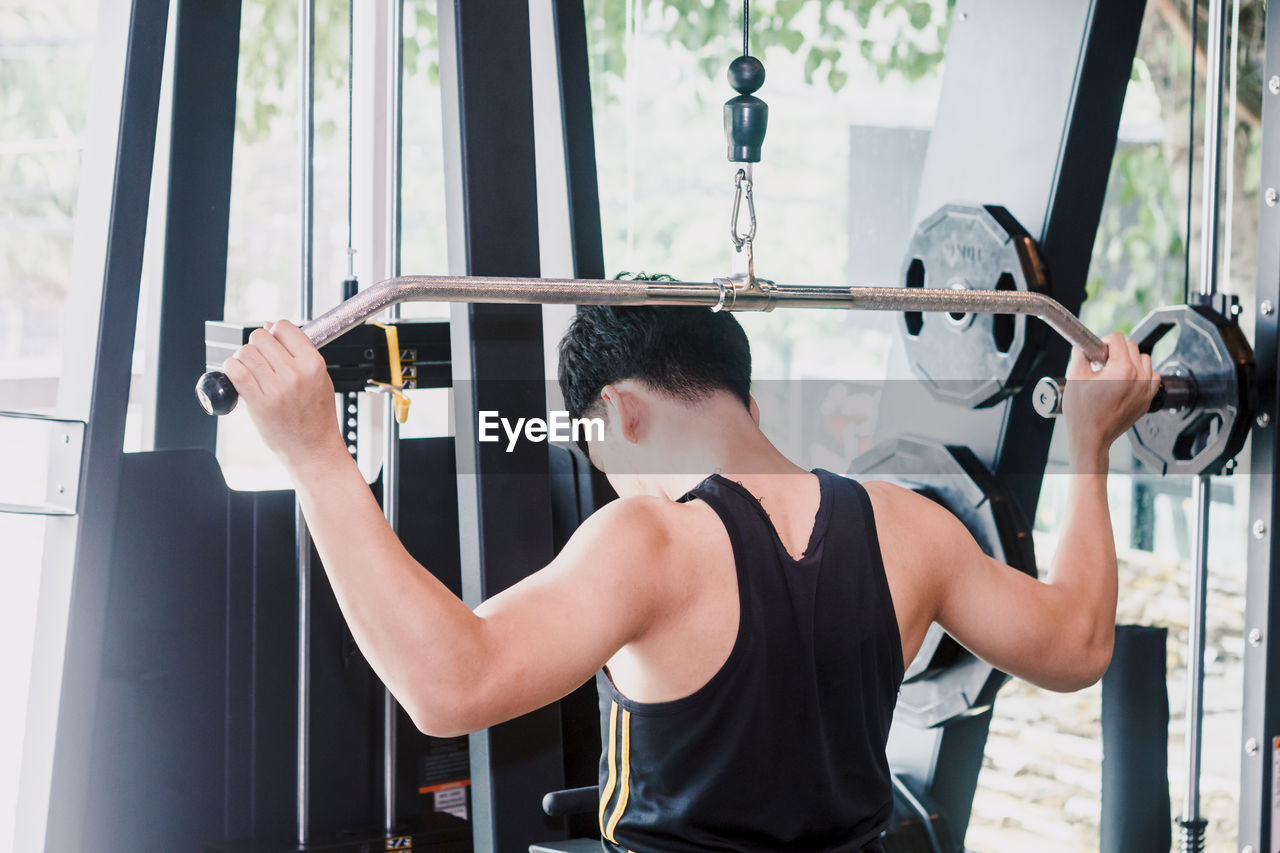 Man lifting barbell in gym