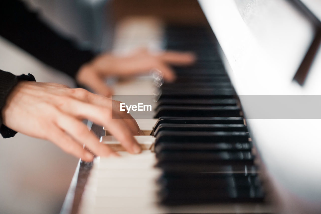 Cropped hands playing piano