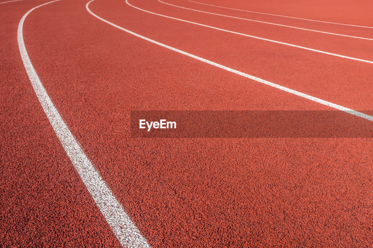 White markings on a red athletic race track in a sports stadium