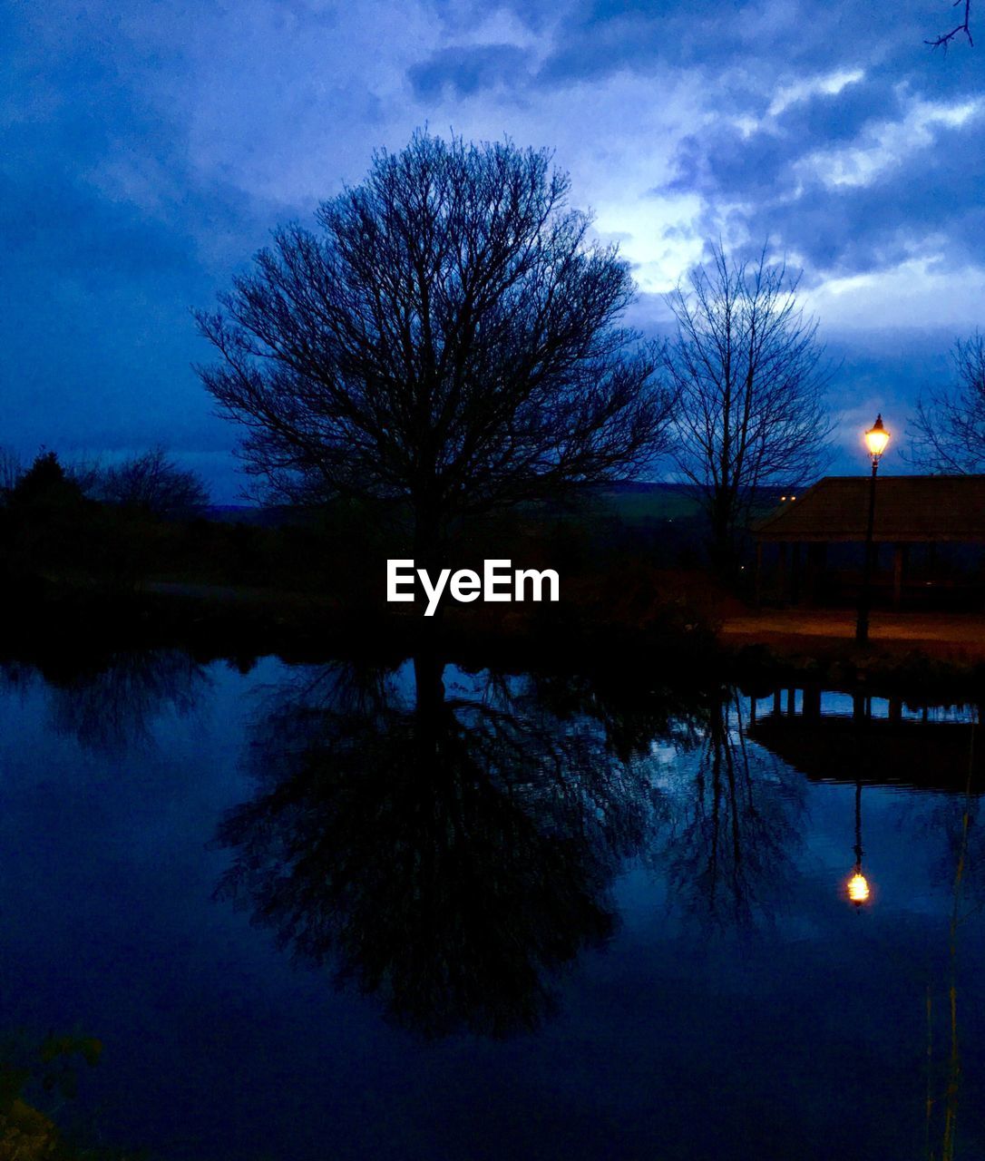 REFLECTION OF TREES ON LAKE AGAINST SKY