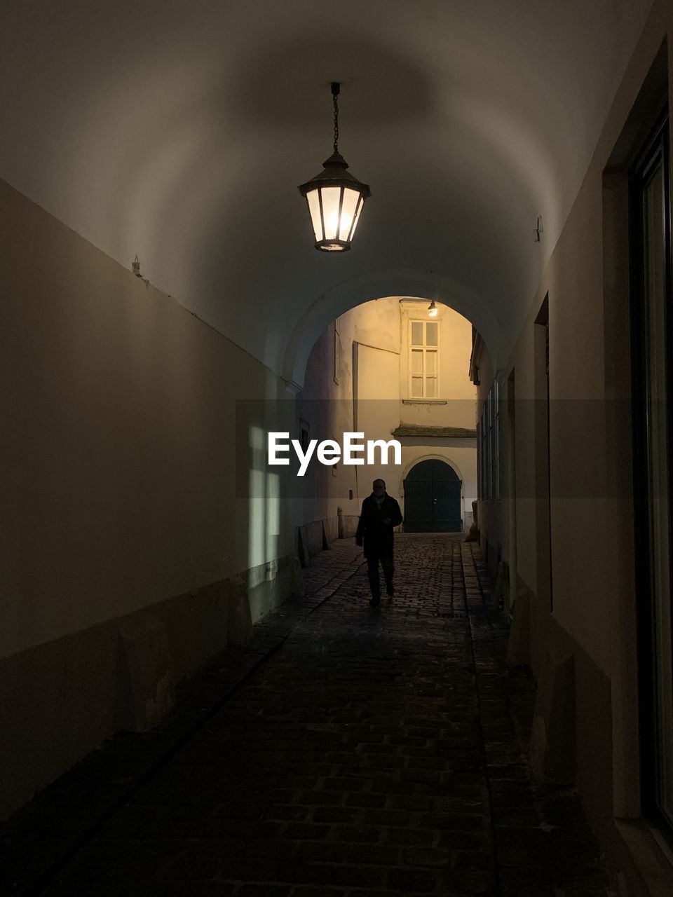 Full length of man walking in illuminated corridor