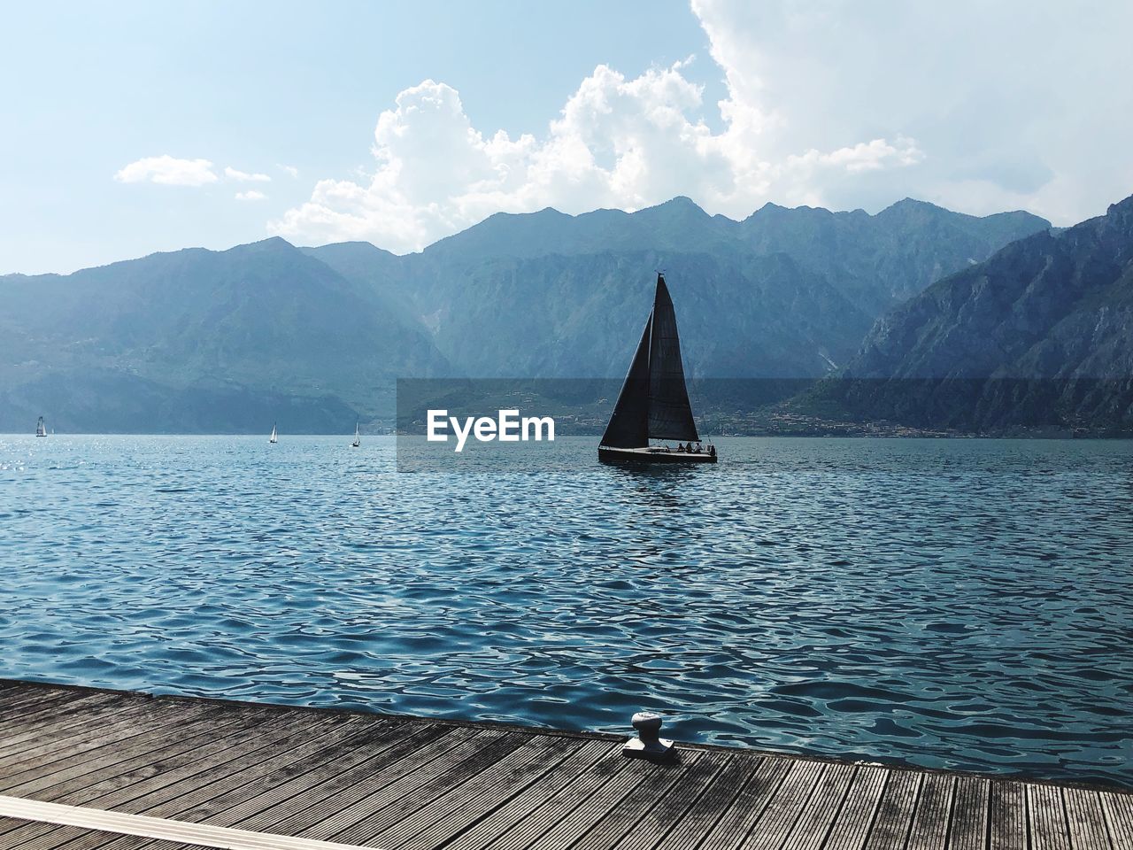 Sailboat in sea against mountains