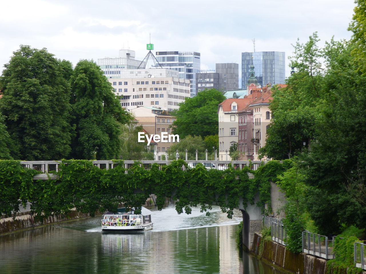 architecture, built structure, building exterior, water, tree, city, river, plant, building, waterway, nature, sky, nautical vessel, travel destinations, residential district, transportation, travel, tourism, waterfront, cityscape, day, no people, cloud, outdoors, body of water, mode of transportation, bridge, city life, landscape, urban skyline, office building exterior