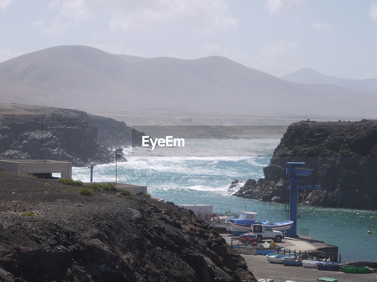Scenic view of sea and mountains against sky