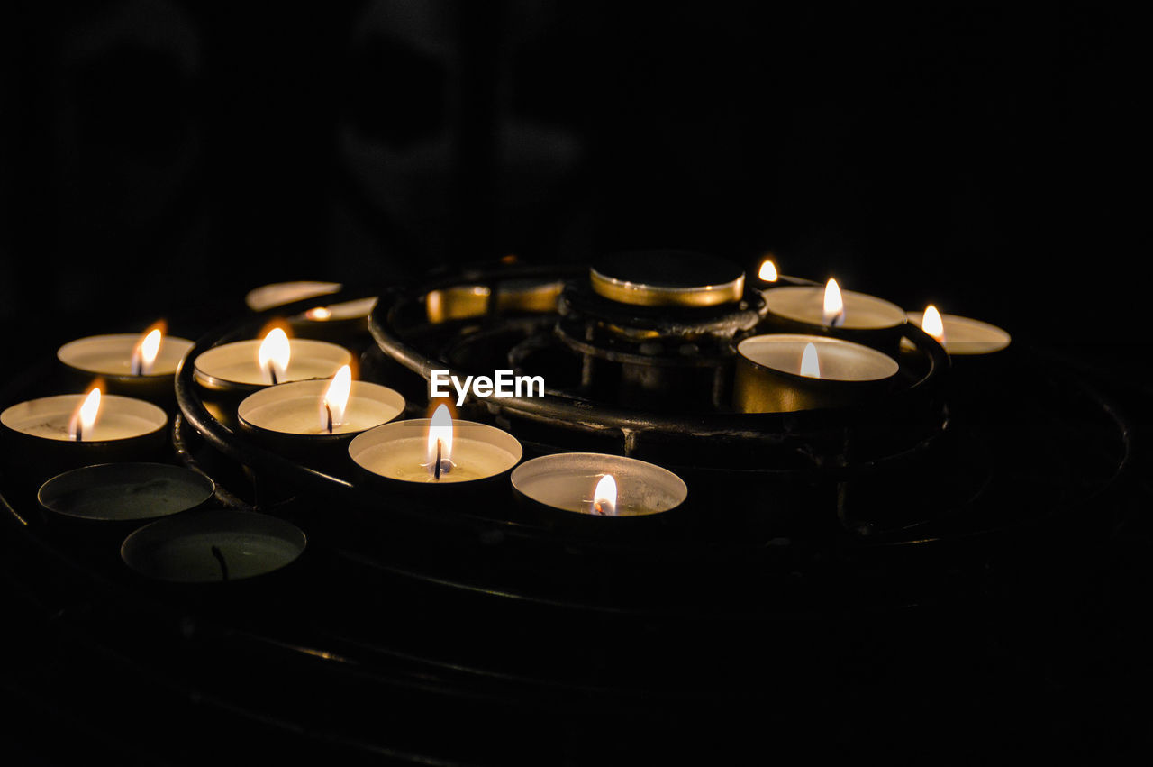 Close-up of lit candles against black background