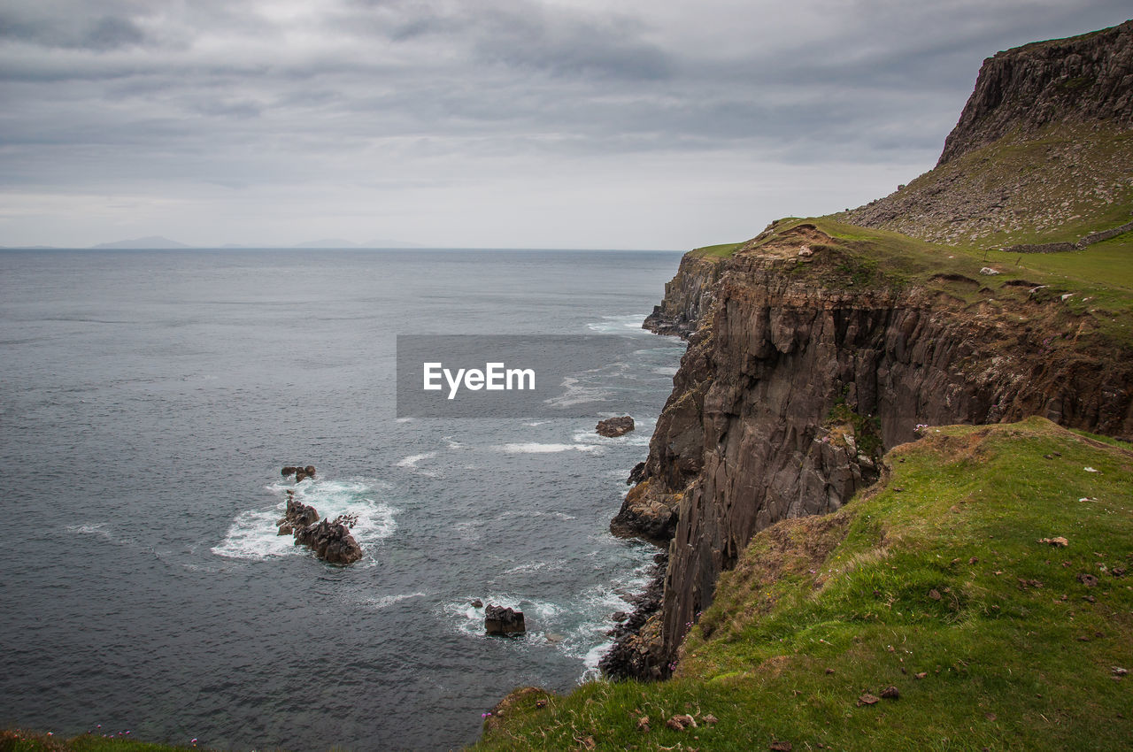 Rocks at the base of steep walls overlooking the sea in the isle of skye