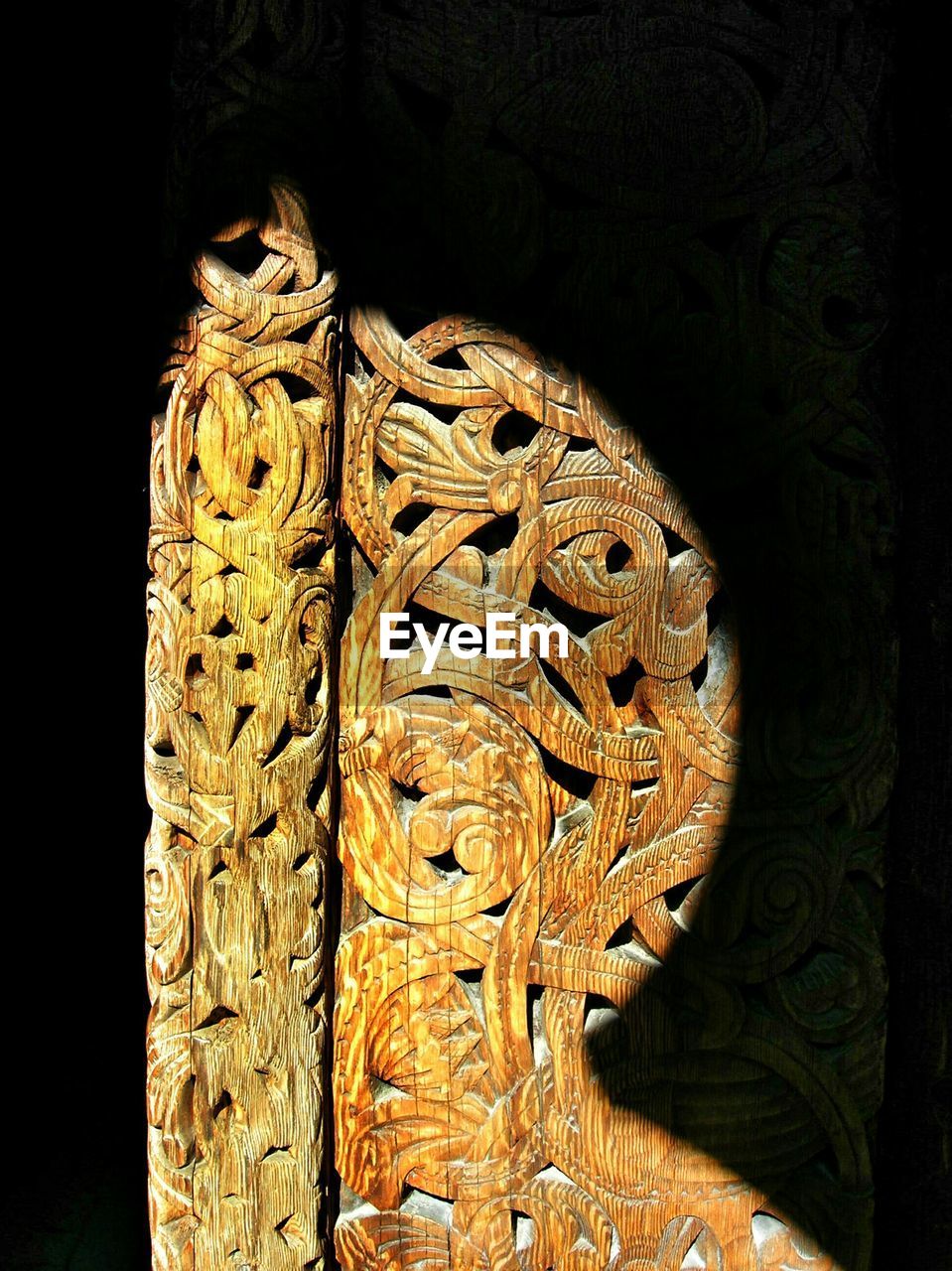 Sunlight falling on carved wooden door