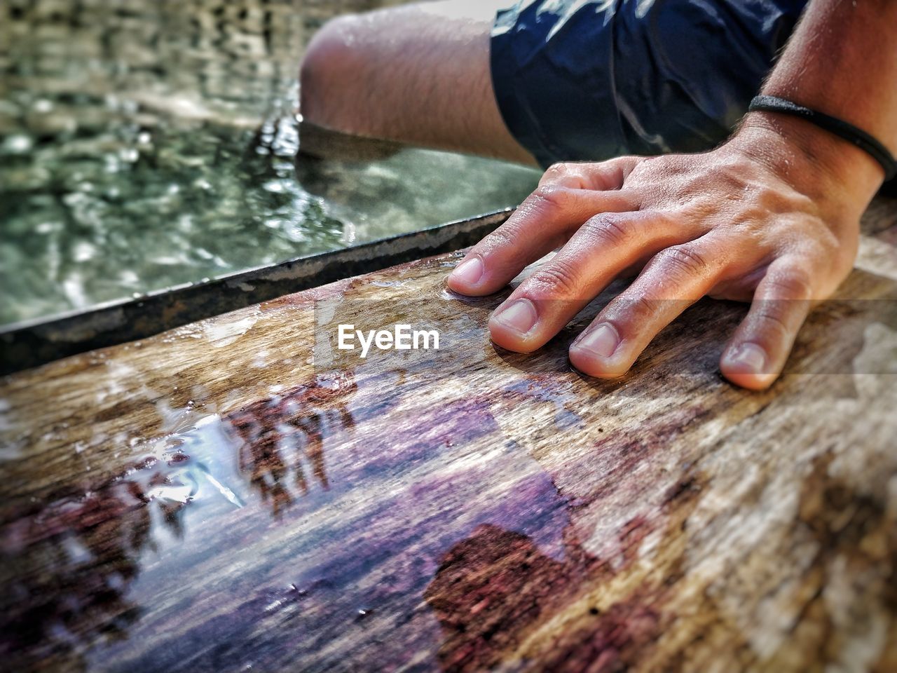 CLOSE-UP OF MAN HOLDING WOOD