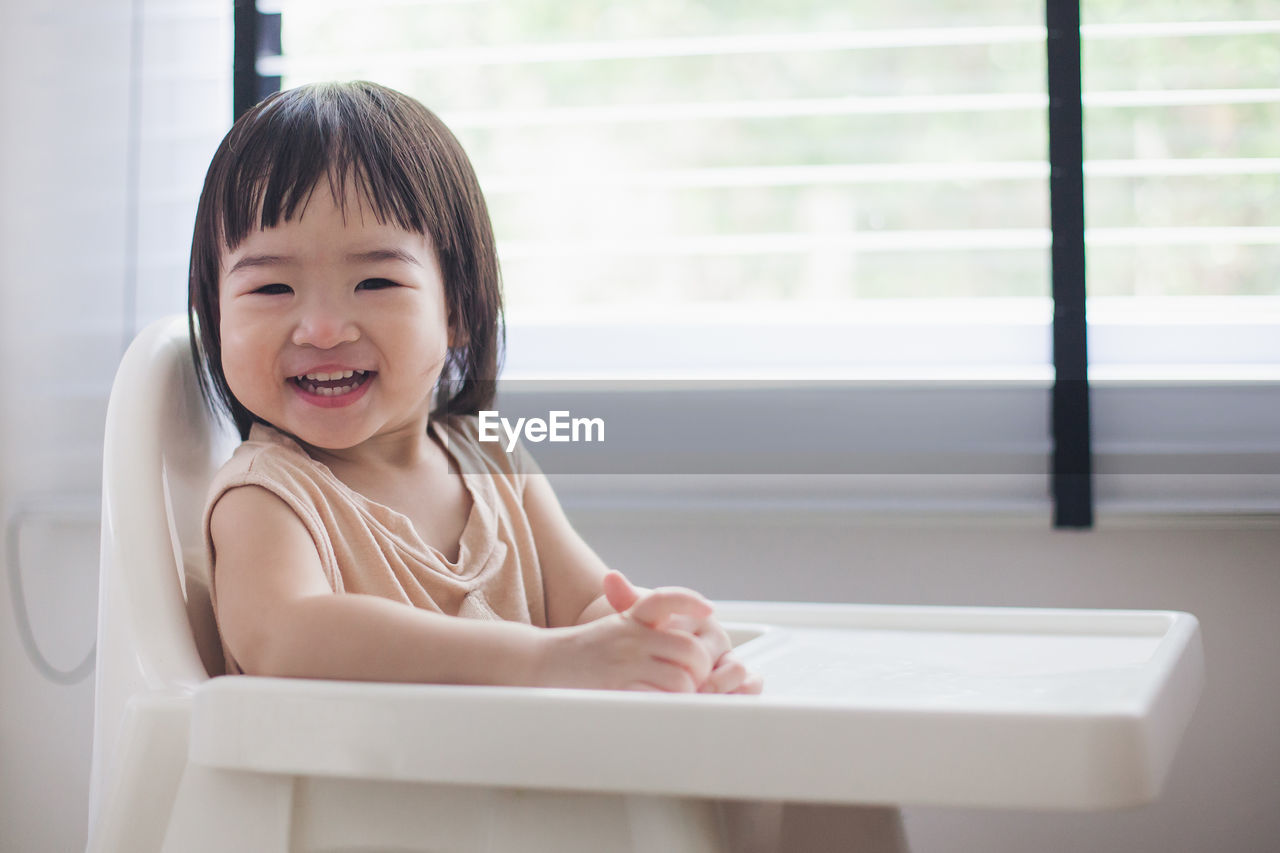 Portrait of smiling girl sitting at home