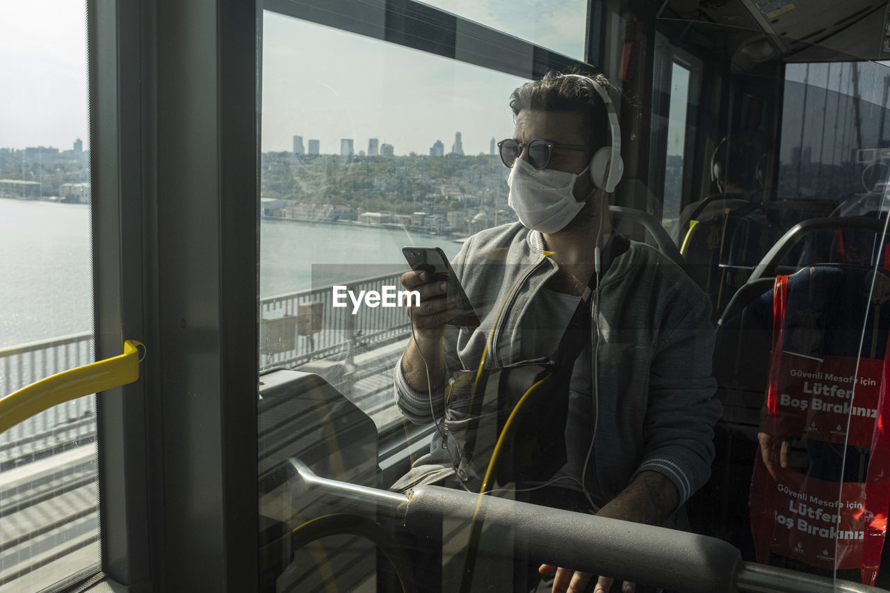 Man wearing mask while traveling in train