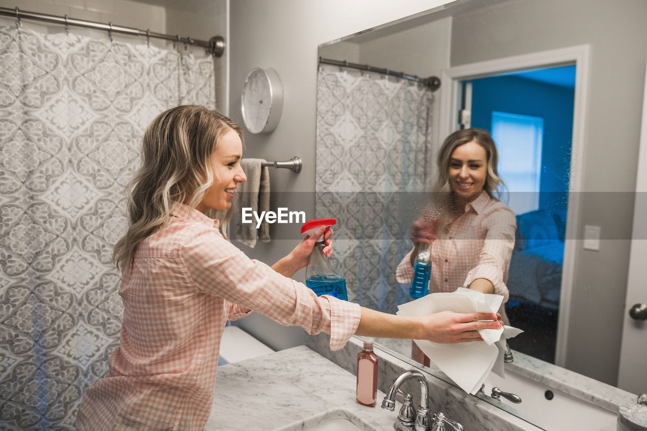 Woman cleaning mirror