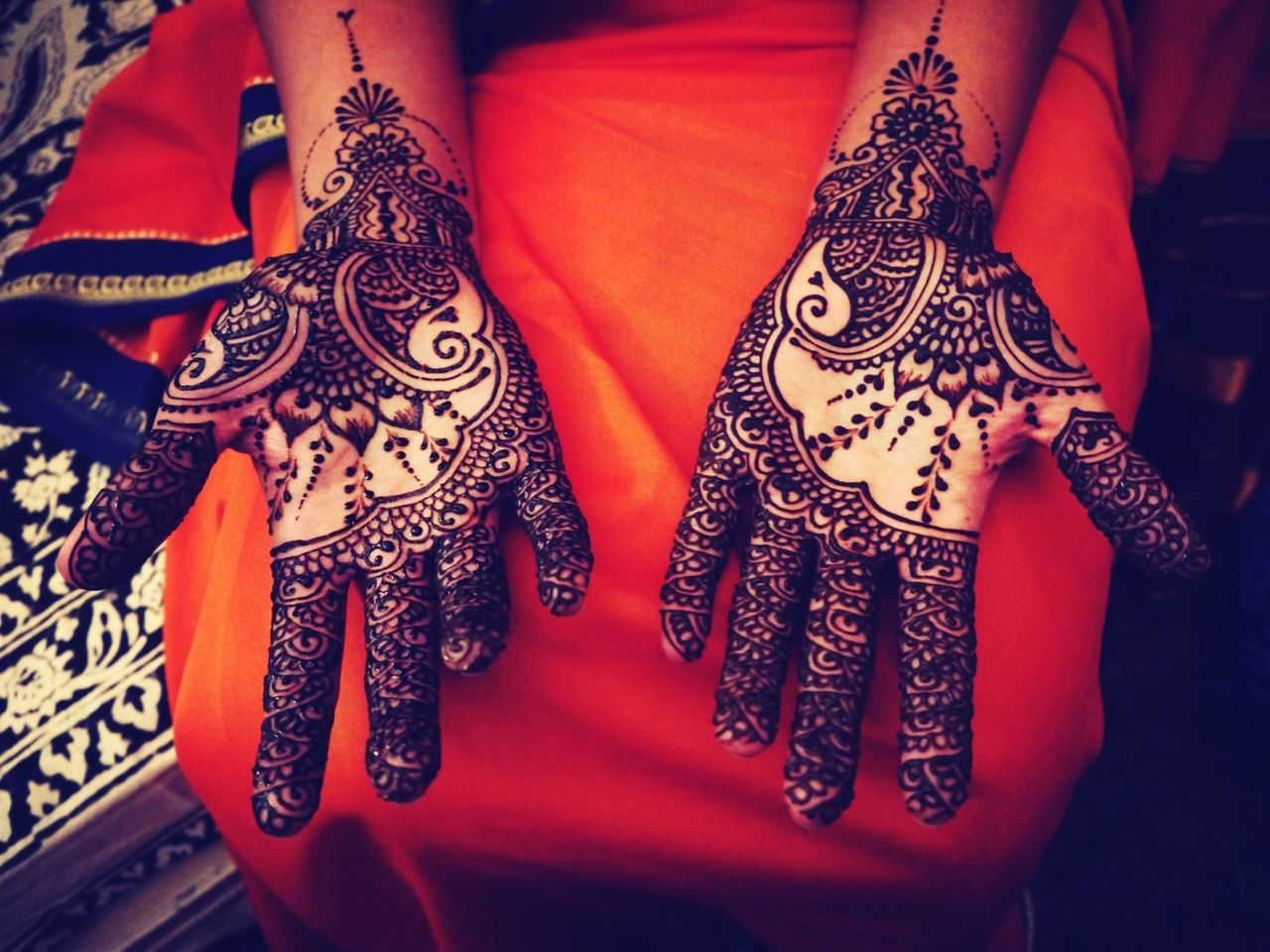 Midsection of woman with henna tattoo on hands
