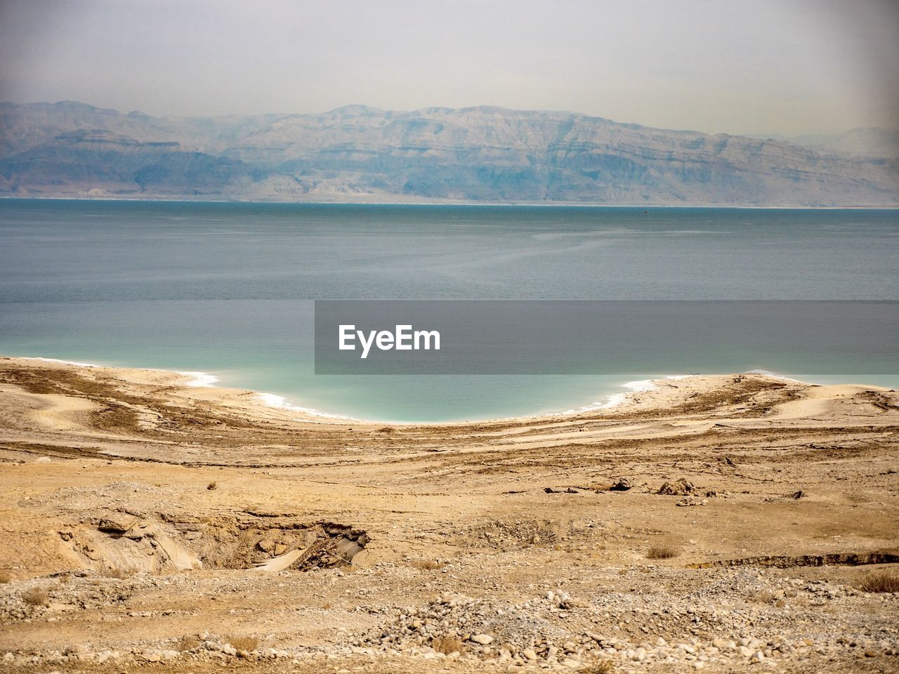 Scenic view of sea and mountains against sky