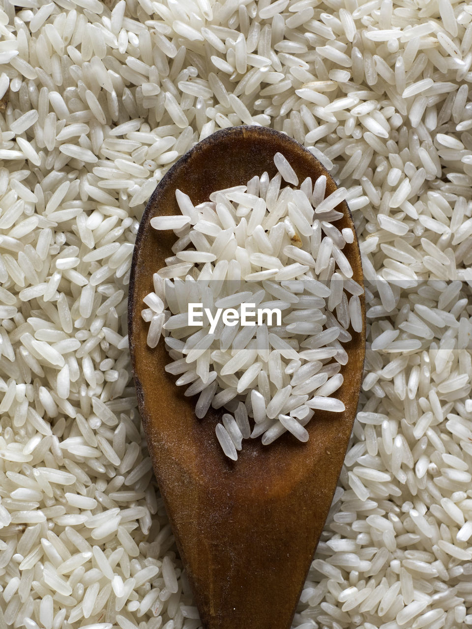 Full frame shot of rice with wooden spoon