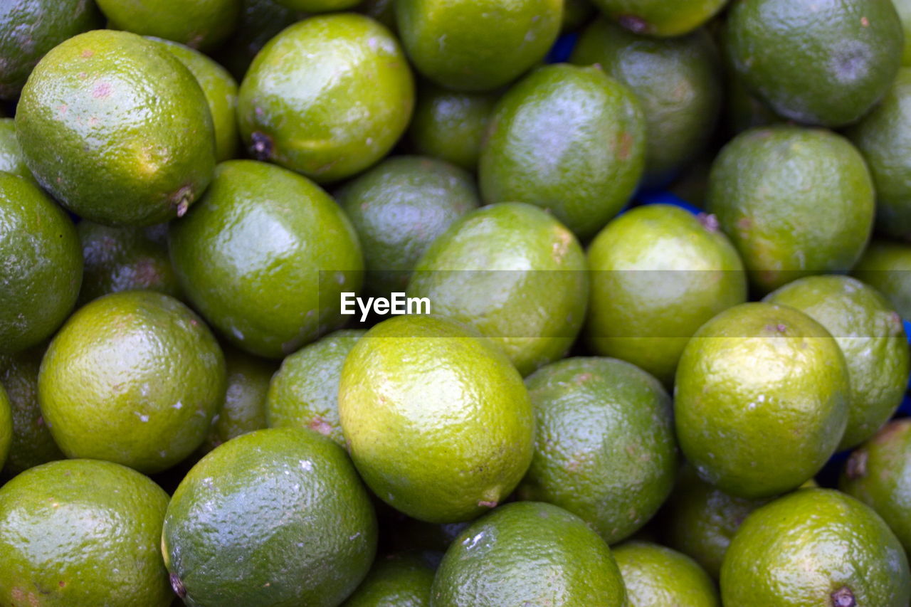 Fresh limes on display on a market stall.