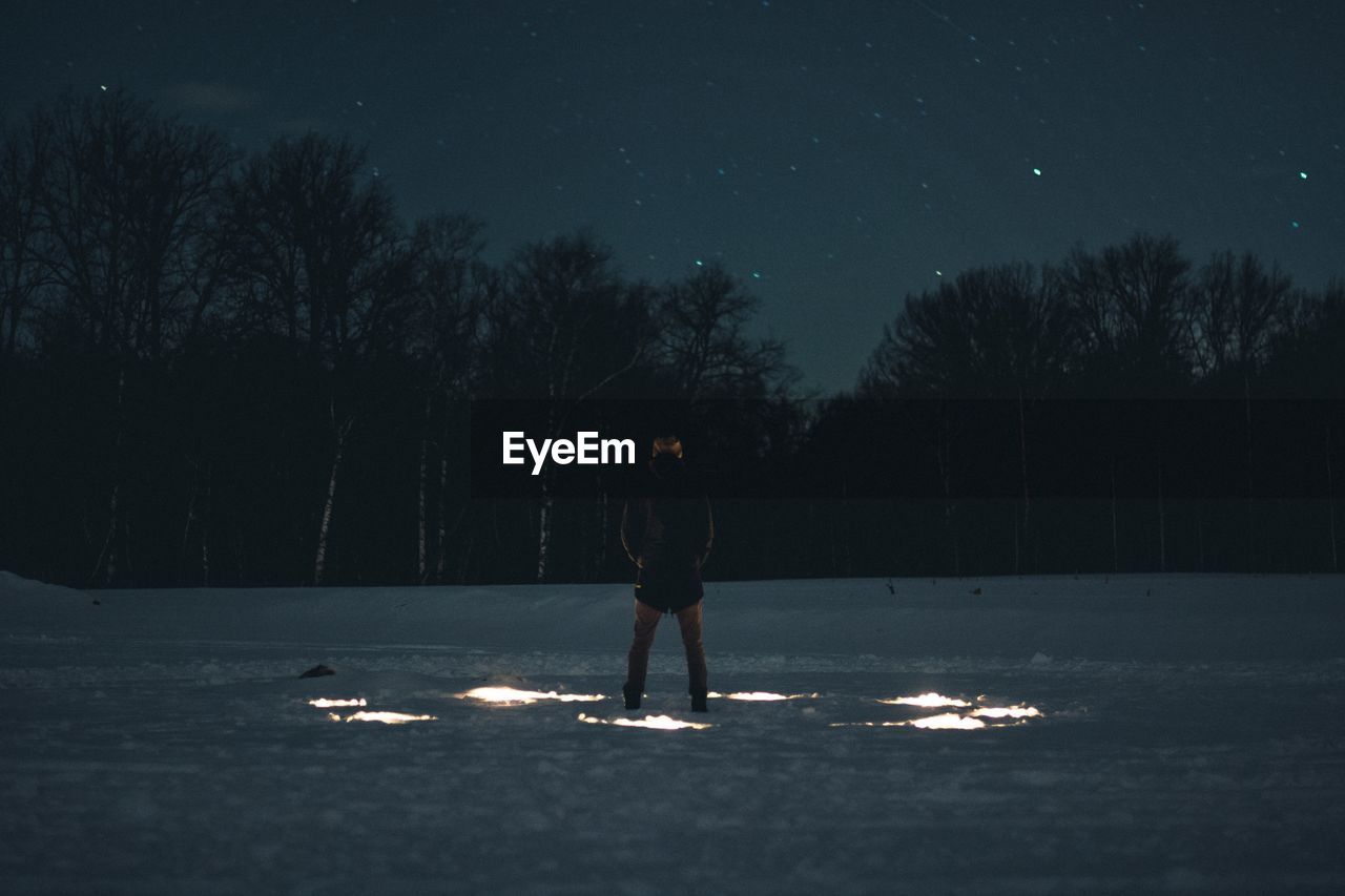 Man standing field at night during winter