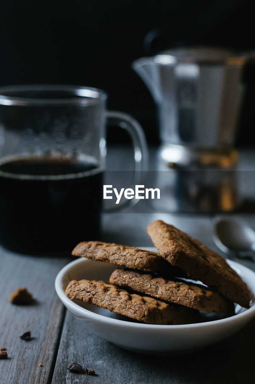 Close-up of cookies in bowl with coffee on table