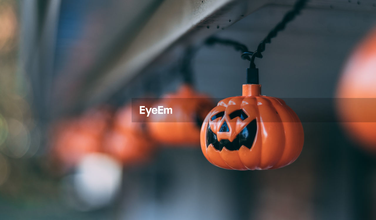 CLOSE-UP OF ORANGE LANTERNS HANGING ON OUTDOORS