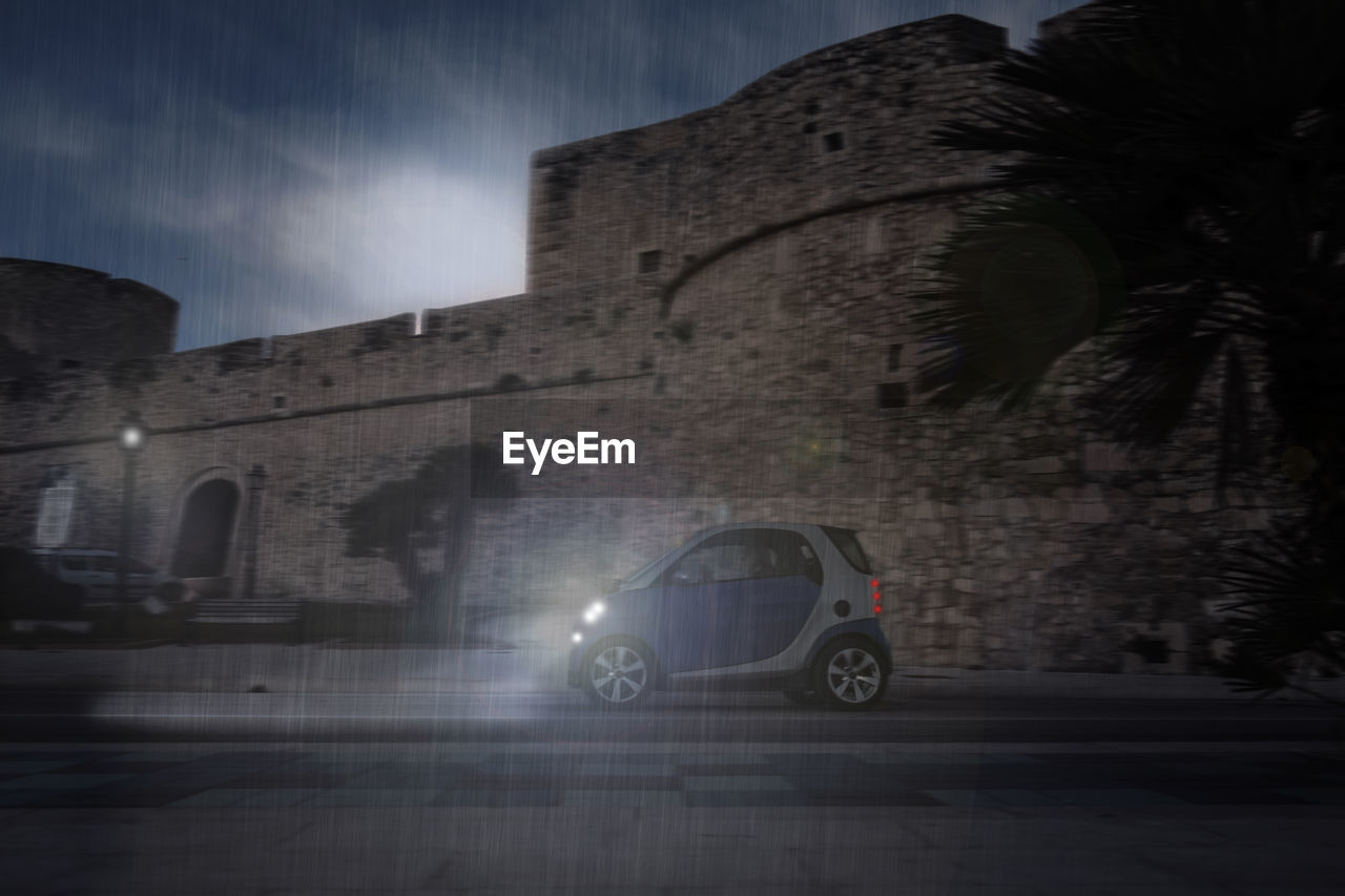 CAR ON ILLUMINATED STREET AT NIGHT