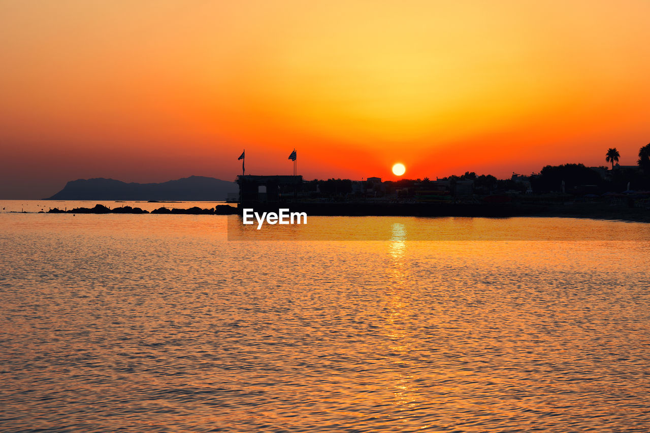 Scenic view of sea against orange sky at sunrise crete