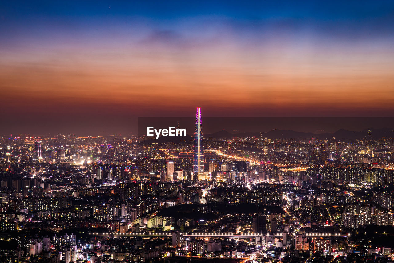 Aerial view of illuminated buildings in city at night