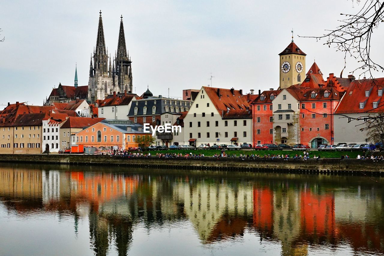 Reflection of regensburg cathedral and buildings on danube river