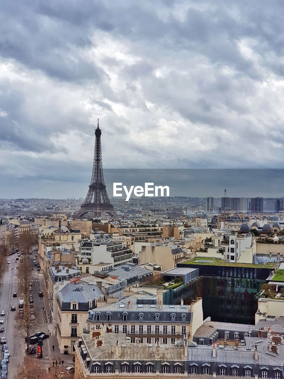 Aerial view of buildings in city against cloudy sky