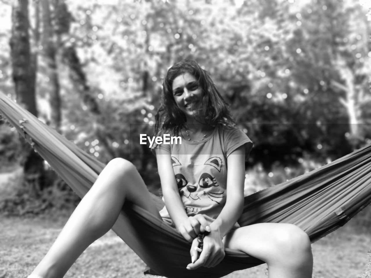 Portrait of woman sitting on hammock outdoors