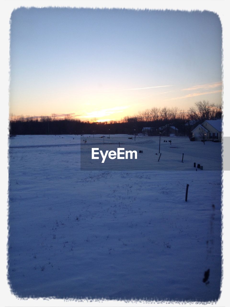 SNOW COVERED LANDSCAPE AT SUNSET