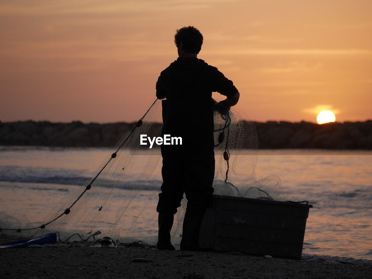 Fisherman on israeli beach at sunset