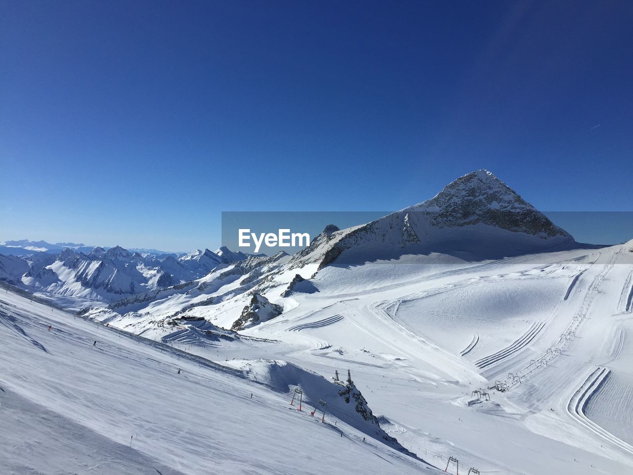 Scenic view of snowcapped mountains against clear blue sky