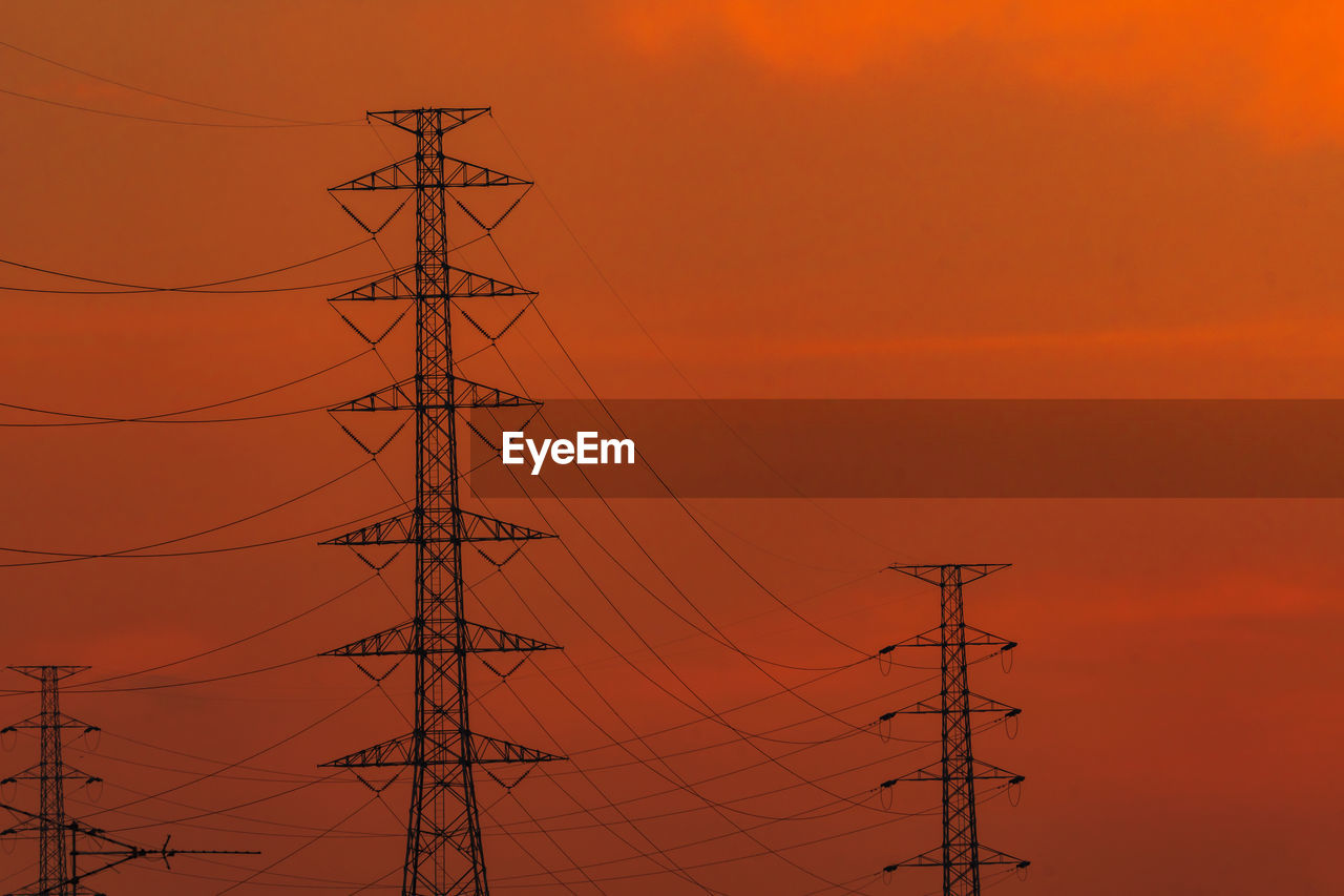 LOW ANGLE VIEW OF SILHOUETTE ELECTRICITY PYLONS AGAINST ROMANTIC SKY