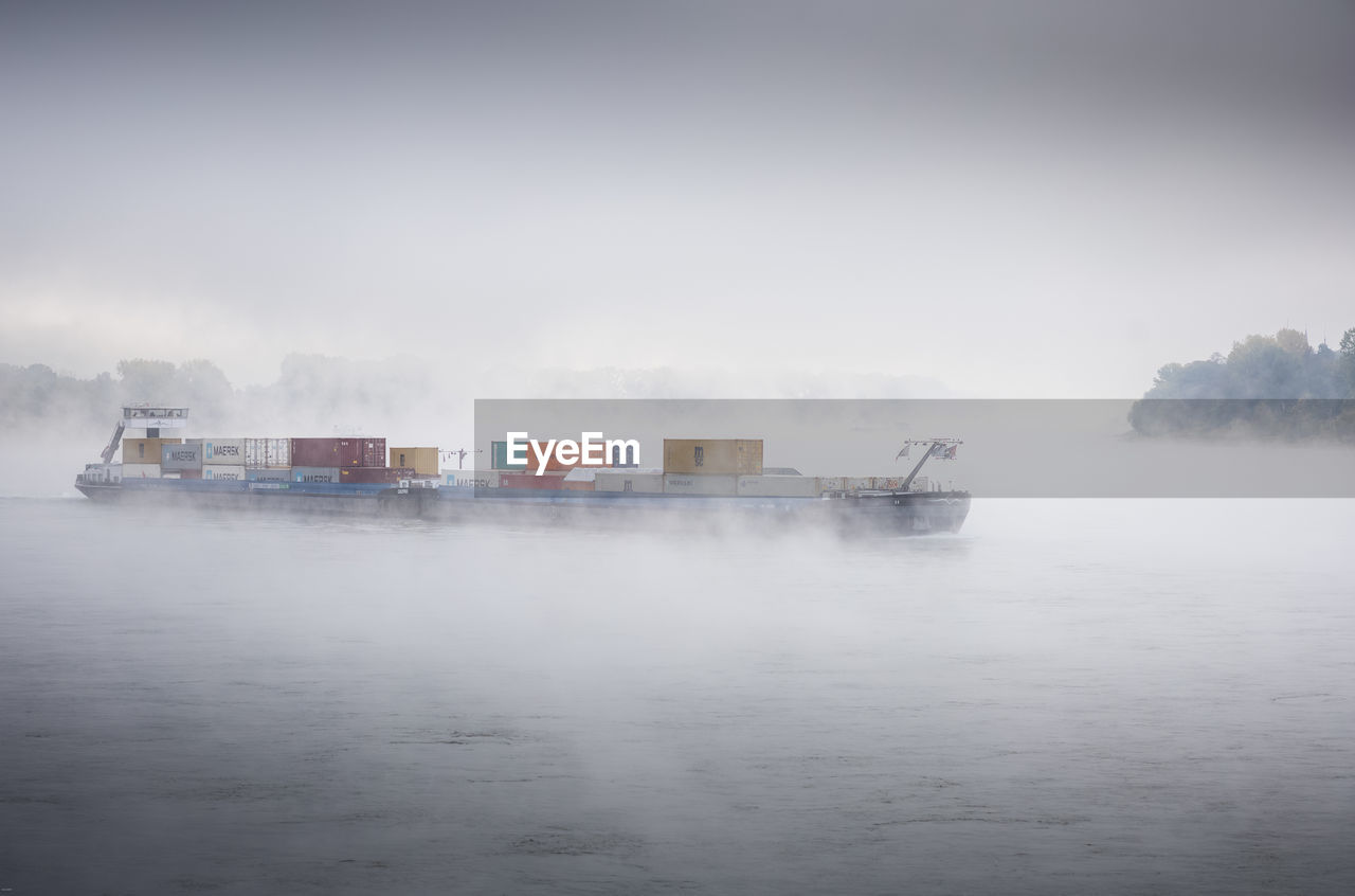 fog, water, transportation, nautical vessel, mist, sea, wave, freight transportation, business, nature, shipping, mode of transportation, ship, ocean, vehicle, morning, sky, environment, watercraft, industry, container, no people, cargo container, outdoors, reflection, copy space, day, pier, cloud, boat, beauty in nature, cargo ship, ferry, snow, scenics - nature, container ship, architecture, coast