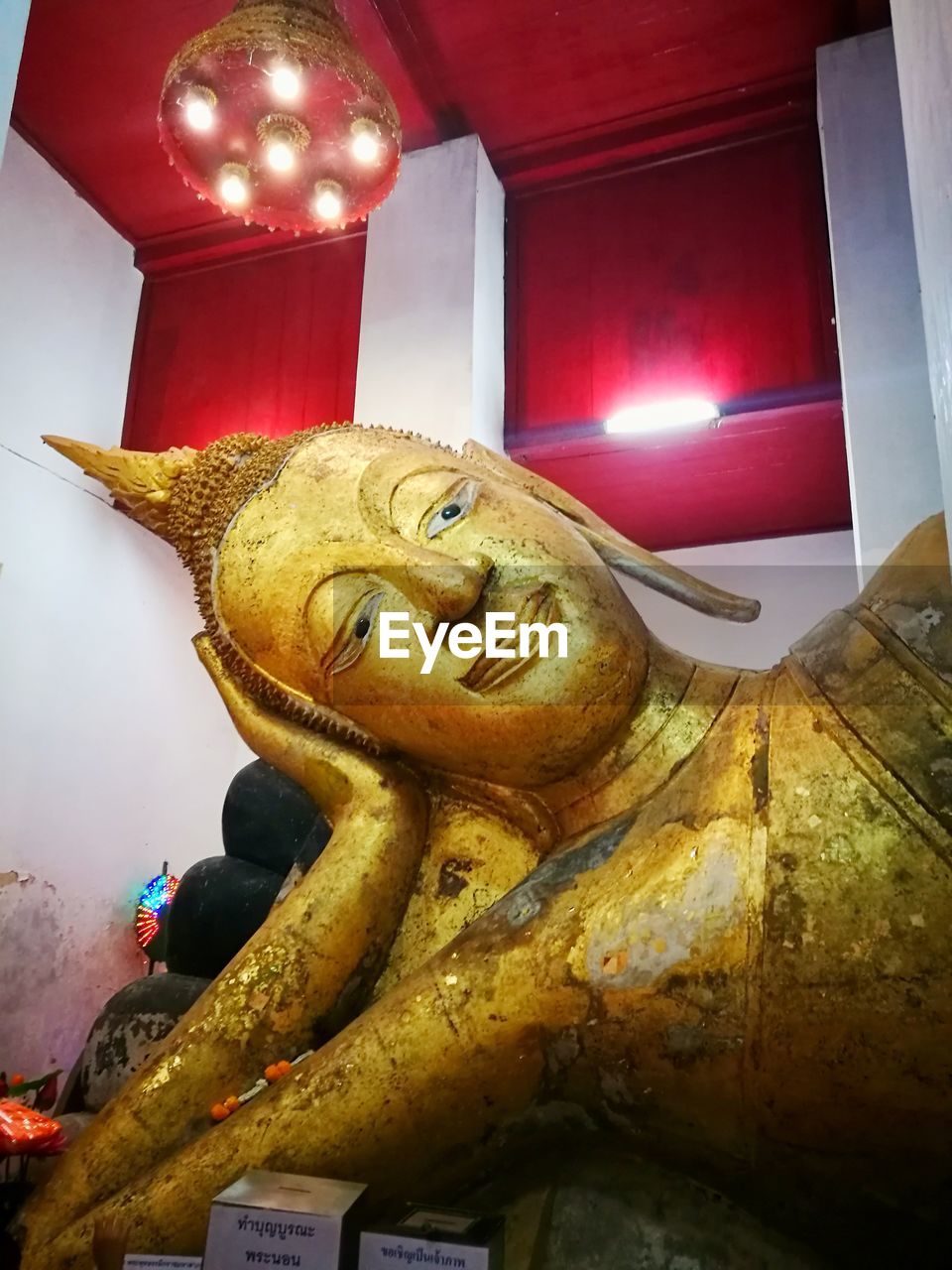 LOW ANGLE VIEW OF STATUE IN ILLUMINATED TEMPLE