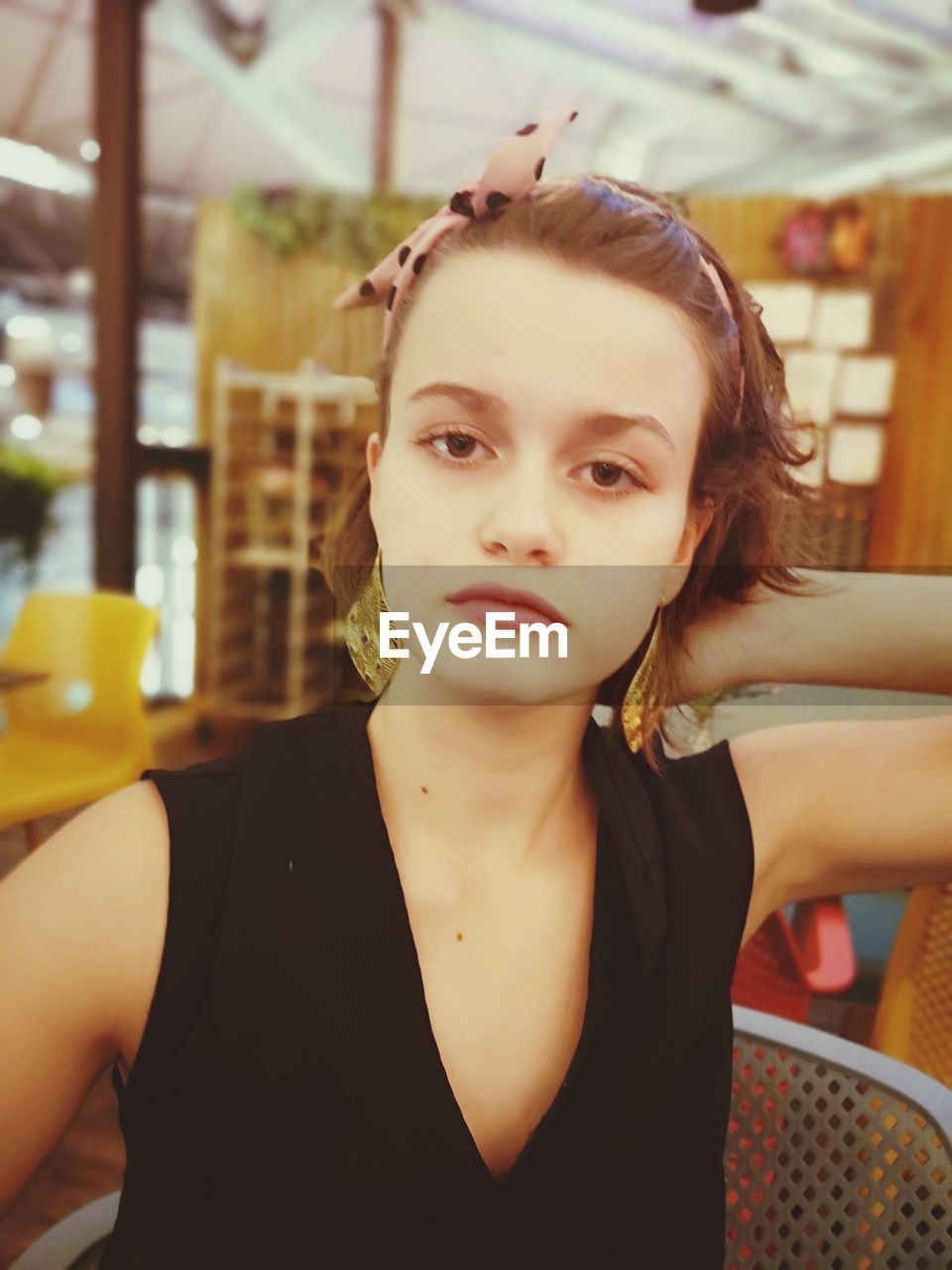 Close-up portrait of young woman sitting in restaurant