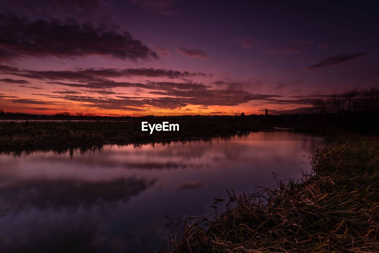 Scenic view of lake against romantic sky at sunset