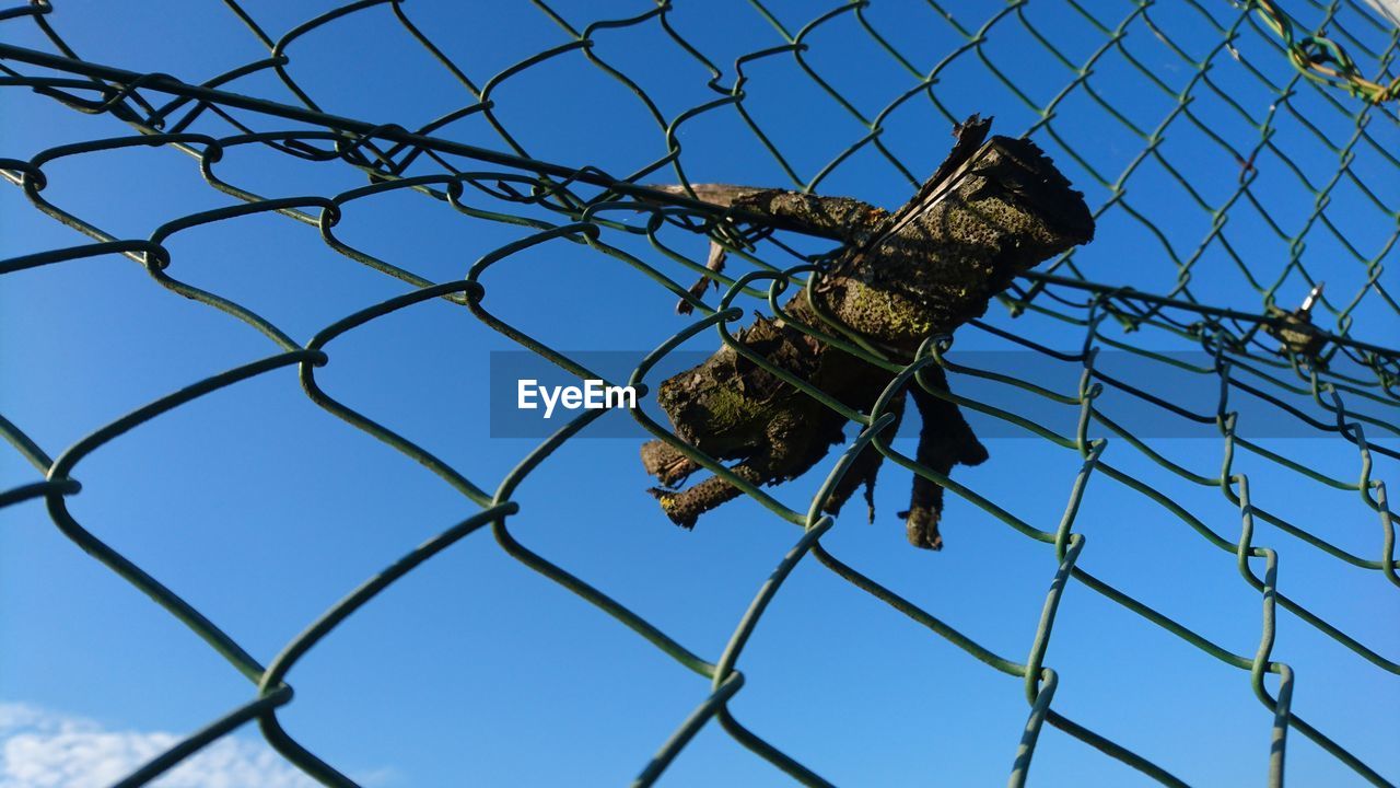 LOW ANGLE VIEW OF CHAINLINK FENCE AGAINST SKY