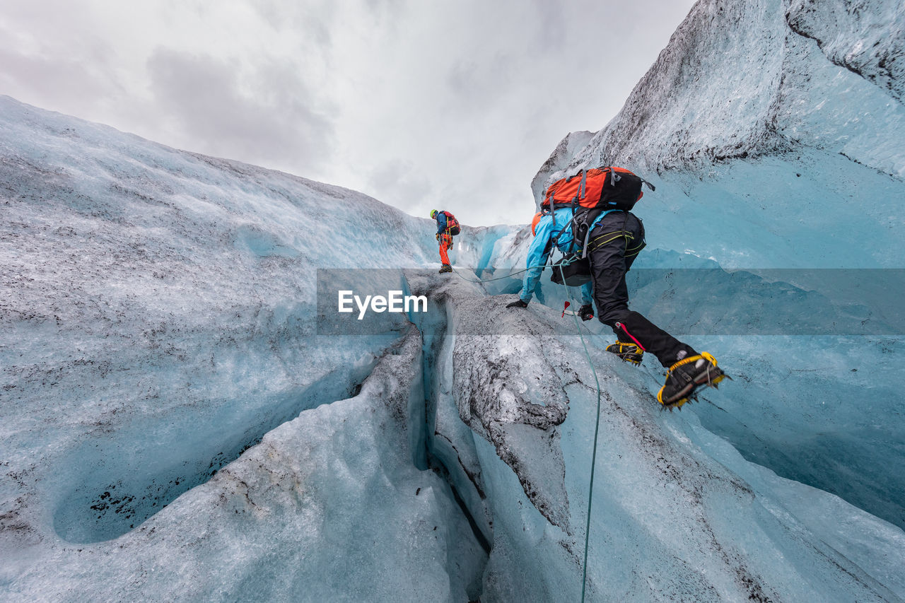 People climbing on frozen mountain