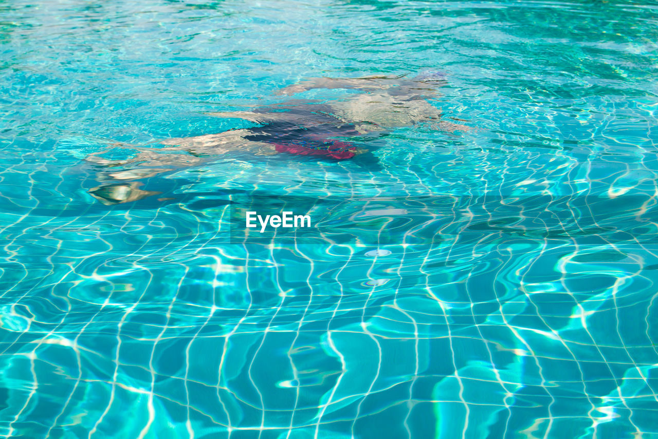 HIGH ANGLE VIEW OF SWIMMING IN SEA