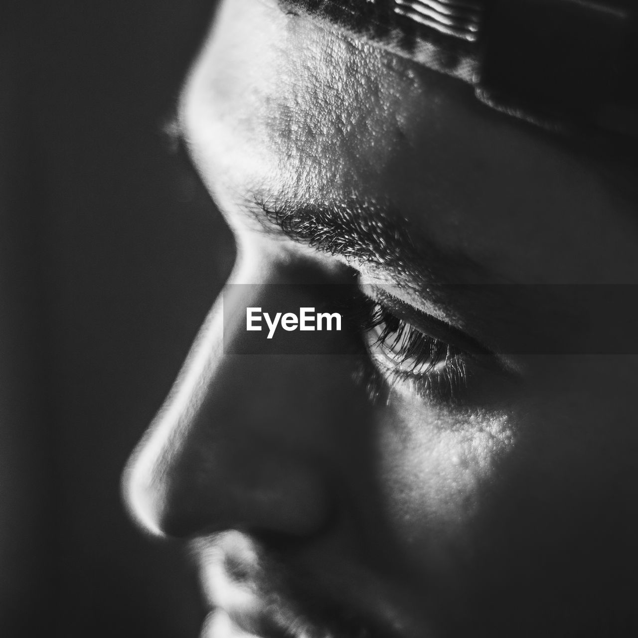Close-up of man looking away in black and white