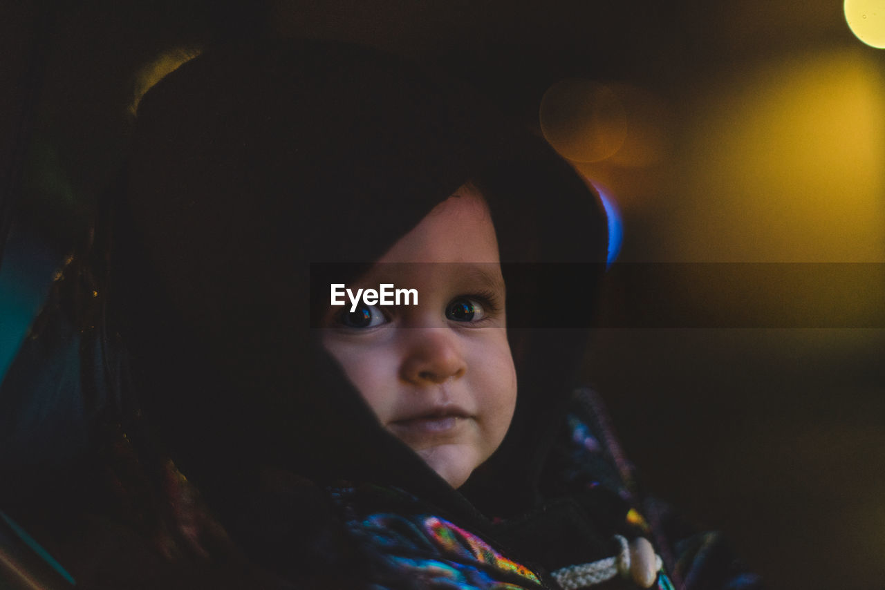 CLOSE-UP PORTRAIT OF CUTE BABY GIRL IN DARK ROOM